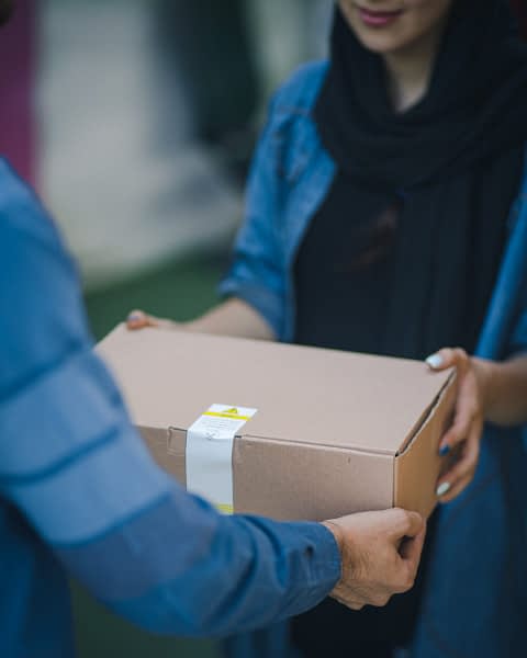 Immagine raffigurante un corriere che consegna un pacco al suo destinatario
