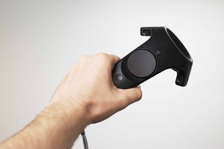 Immagine raffigurante una mano che impugna un controller/gamepad per la realtà virtuale